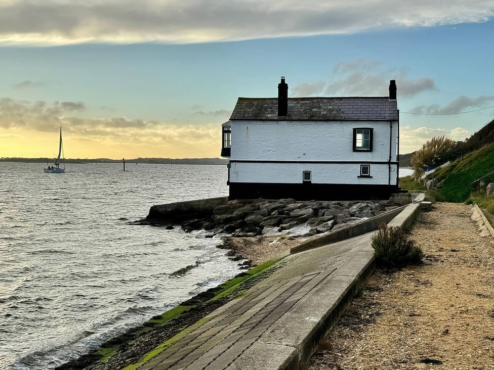 A house by the water with a boat in the background at TBC in 