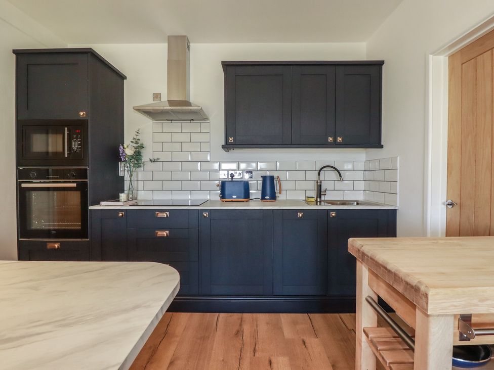 A kitchen with cabinets and appliances at Rollies Retreat in Fowey