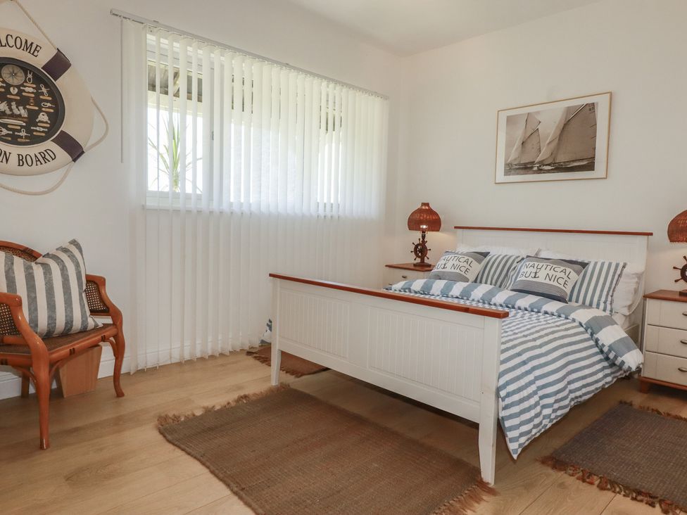 A bedroom with a bed and striped linens at Rollies Retreat in Fowey