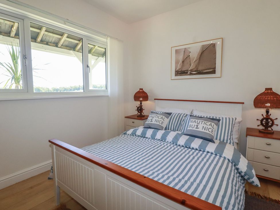 A bedroom with a bed and nautical themed decor at Rollies Retreat in Fowey
