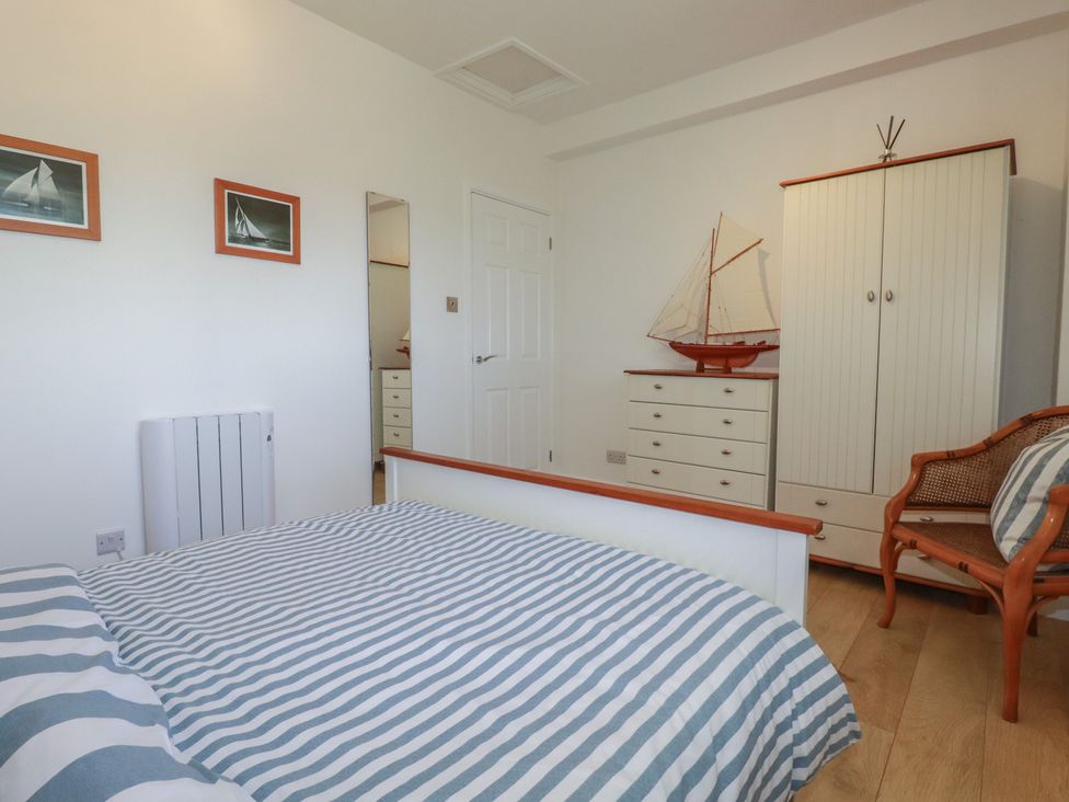 A bedroom with a bed and wardrobe at Rollies Retreat in Fowey