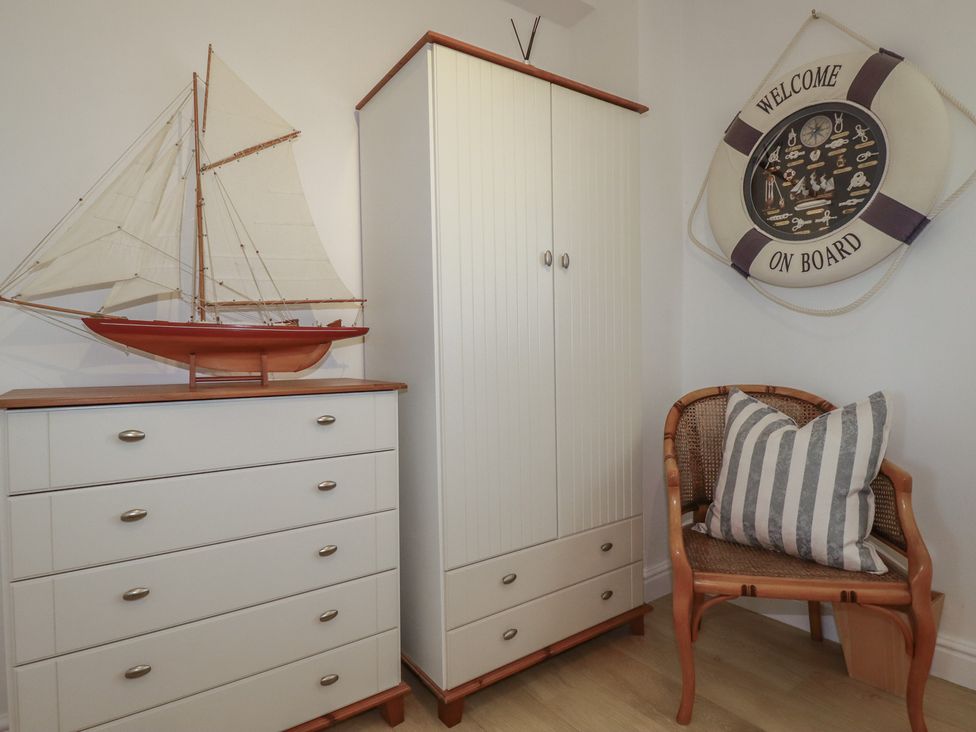 An indoor corner with a model sailboat and furniture at Rollies Retreat in Fowey