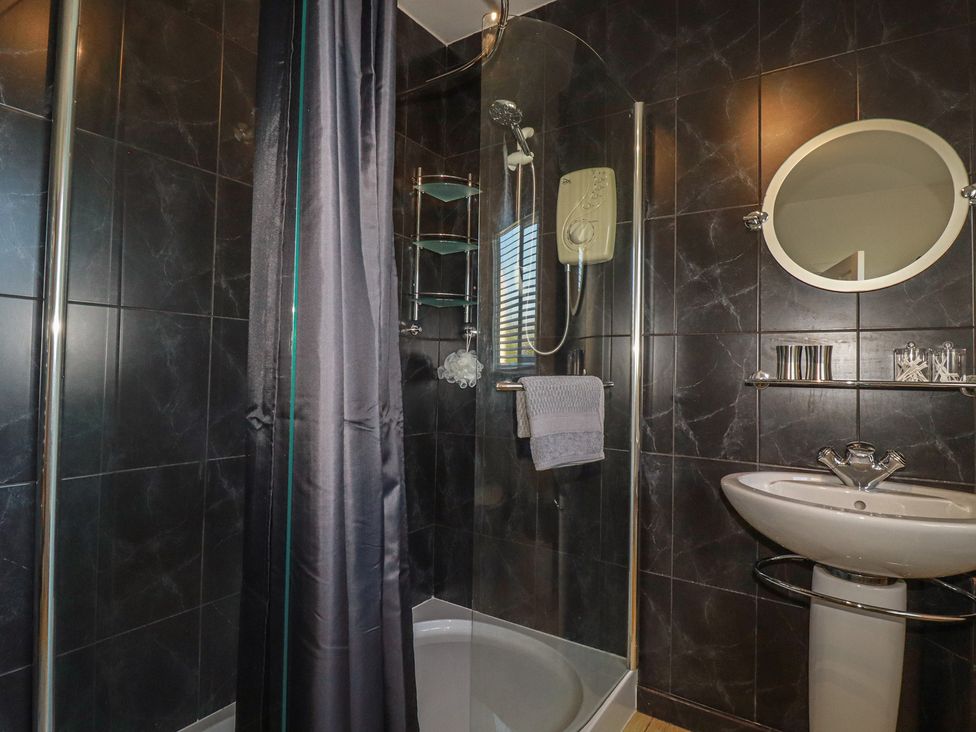 A bathroom with a shower and sink at Rollies Retreat in Fowey