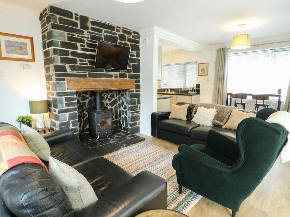 A living room with a fireplace and sofas at Dyffryn in Betws-Y-Coed
