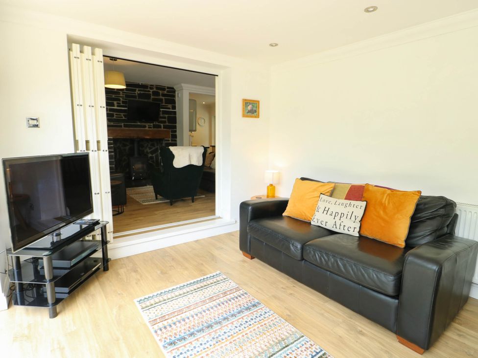 A living room with a sofa and television at Dyffryn in Betws-Y-Coed