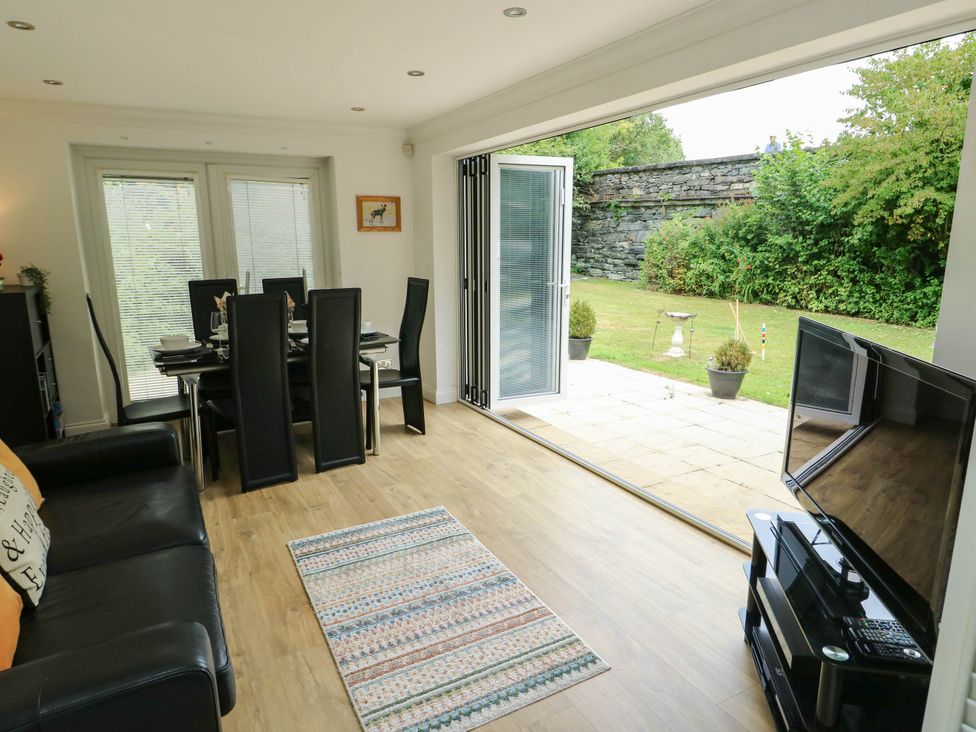A living room with a dining area and sliding doors at Dyffryn in Betws-Y-Coed