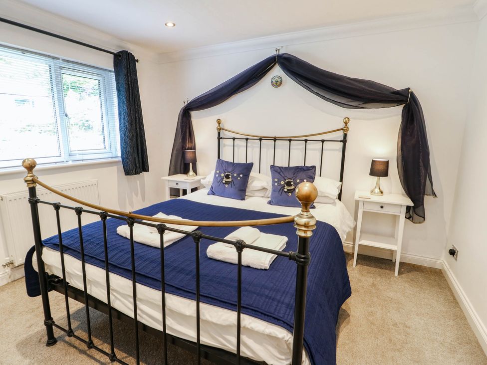 A bedroom with a bed and nightstands at Dyffryn in Betws-Y-Coed
