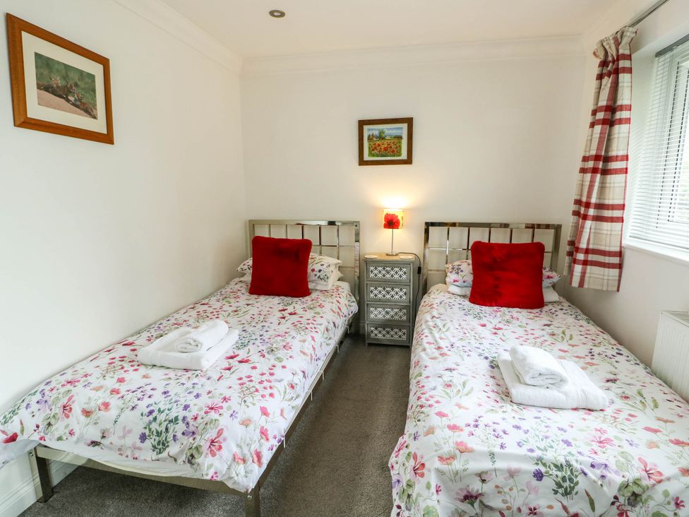 A bedroom with twin beds and a bedside table at Dyffryn in Betws-Y-Coed