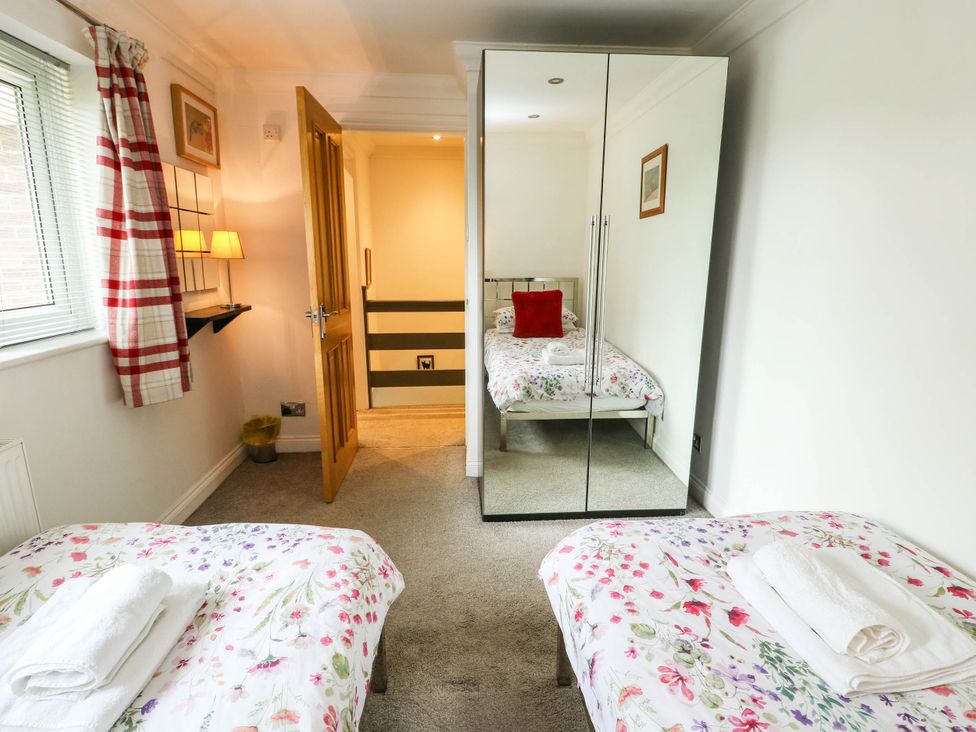 A bedroom with two beds and a mirror wardrobe at Dyffryn in Betws-Y-Coed