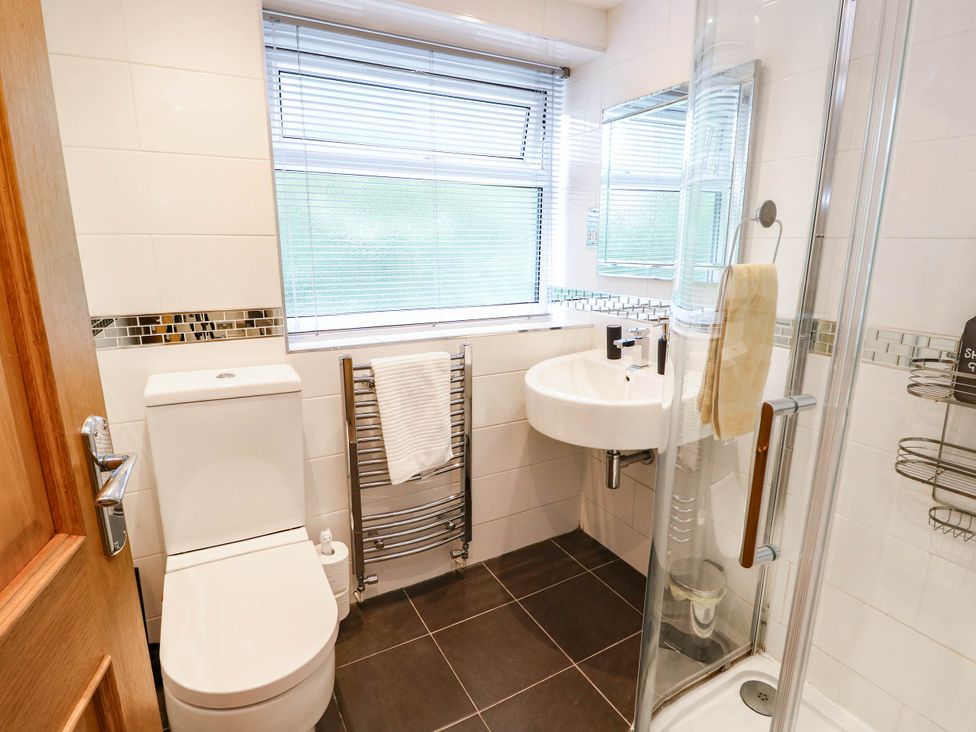A bathroom with a sink, toilet, and shower at Dyffryn in Betws-Y-Coed