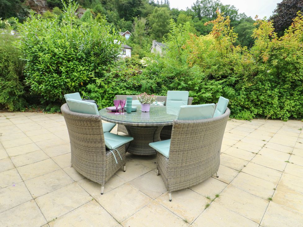 An outdoor dining area with a table and chairs at Dyffryn in Betws-Y-Coed