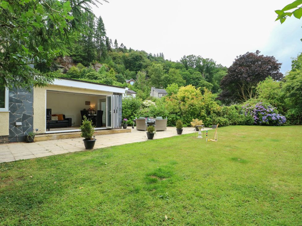 A garden with patio and outdoor furniture at Dyffryn in Betws-Y-Coed