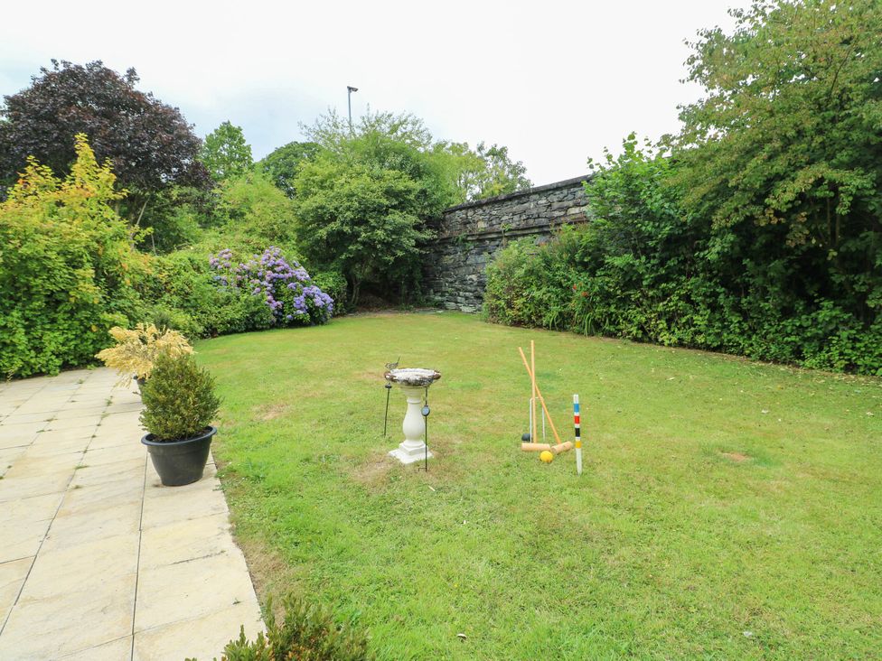 A garden with a stone wall and croquet set at Dyffryn in Betws-Y-Coed
