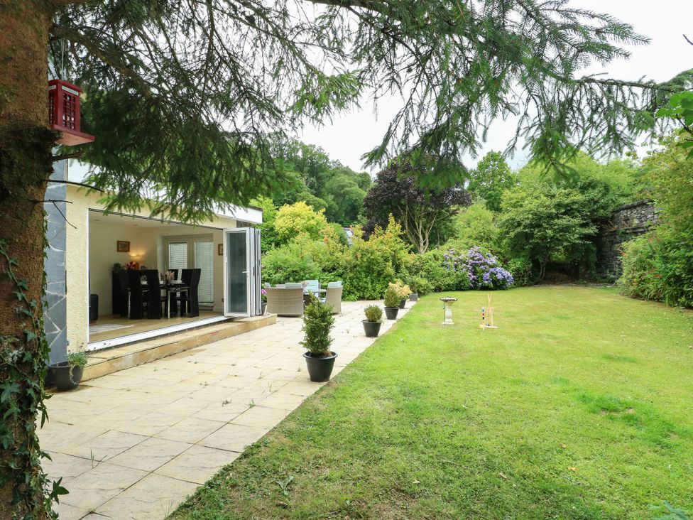 A garden with a patio area and potted plants at Dyffryn in Betws-Y-Coed