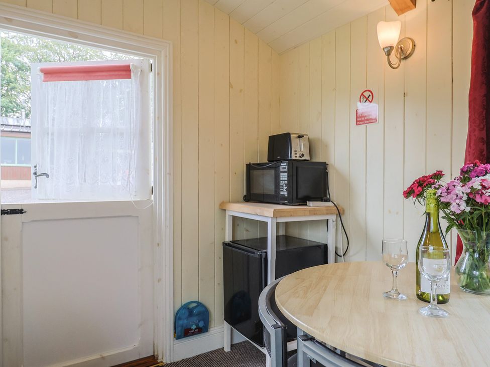 A kitchen with a table and chairs at Shepherds Hut at East Hill Pride Four Elms Hill Nr. Sidmouth