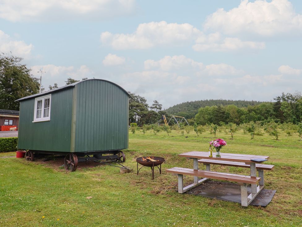 A shepherd's hut with a picnic table and fire pit at Shepherds Hut at East Hill Pride Four Elms Hill Nr. Sidmouth