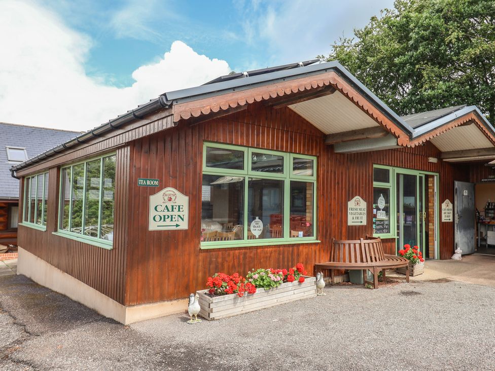 An outdoor cafe with a bench and flowers at Shepherds Hut at East Hill Pride Four Elms Hill Nr. Sidmouth
