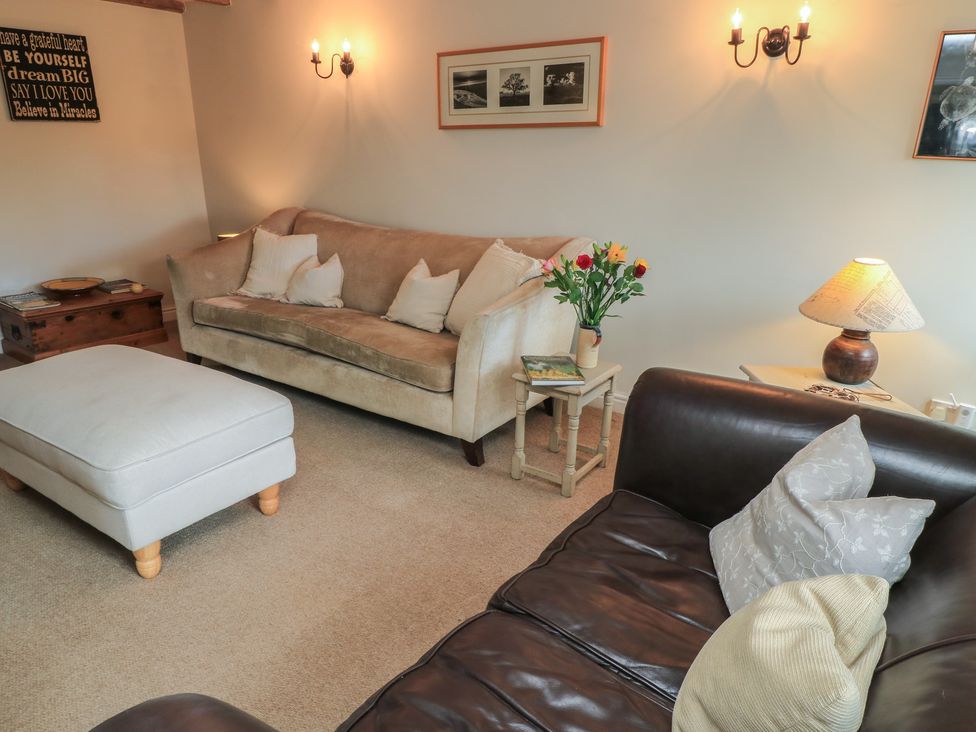 A living room with a sofa and coffee table at 2 The Gardens Lechlade