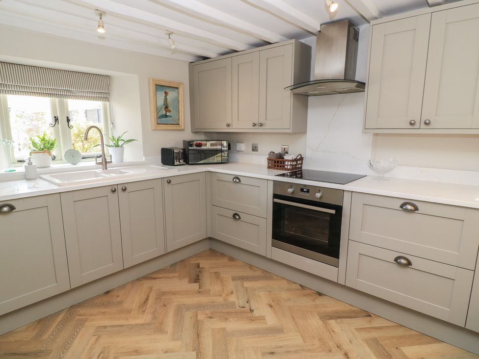 A kitchen with cabinets, oven, sink, and microwave at 2 The Gardens Lechlade