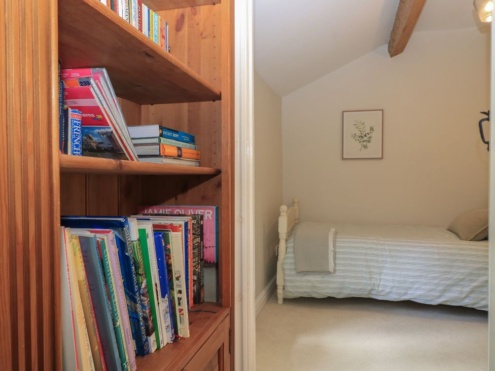 A bedroom with a bed and bookshelf at 2 The Gardens Lechlade