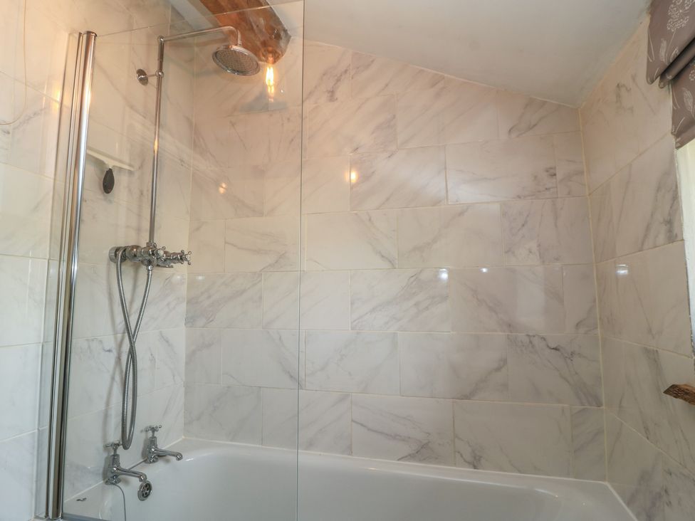 A bathroom with a shower and bathtub at 2 The Gardens in Lechlade