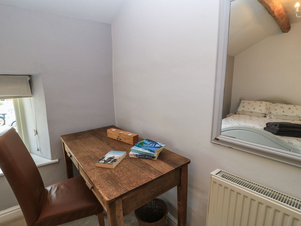 A desk with a chair and books in a bedroom at 2 The Gardens Lechlade