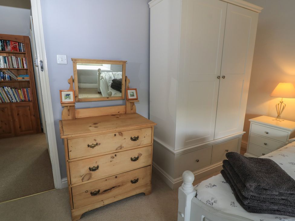 A bedroom with a dresser and a wardrobe at 2 The Gardens in Lechlade