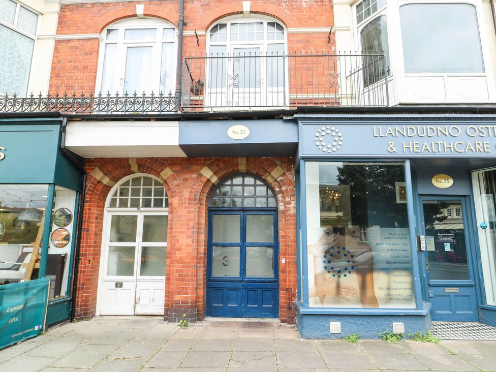 A building facade with doors and sign at Flat 3 in Llandudno