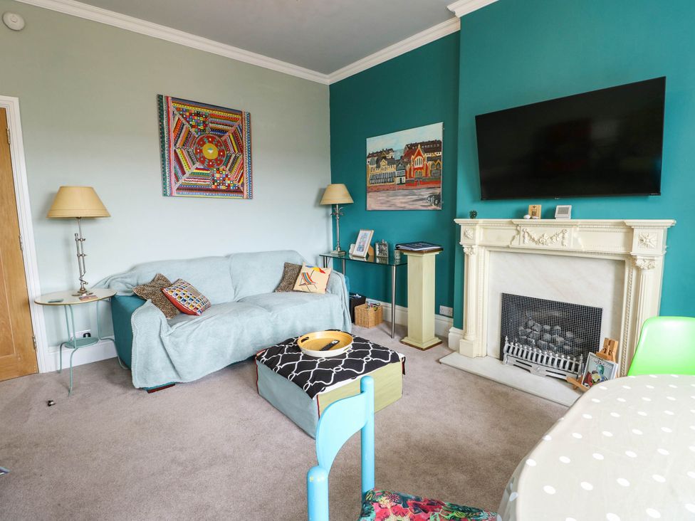 A living room with a sofa and fireplace at Flat 3 in Llandudno