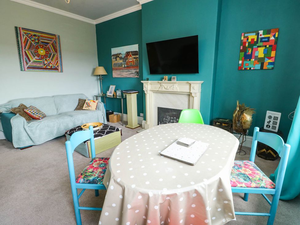 A living room with a sofa and a dining table at Flat 3 in Llandudno