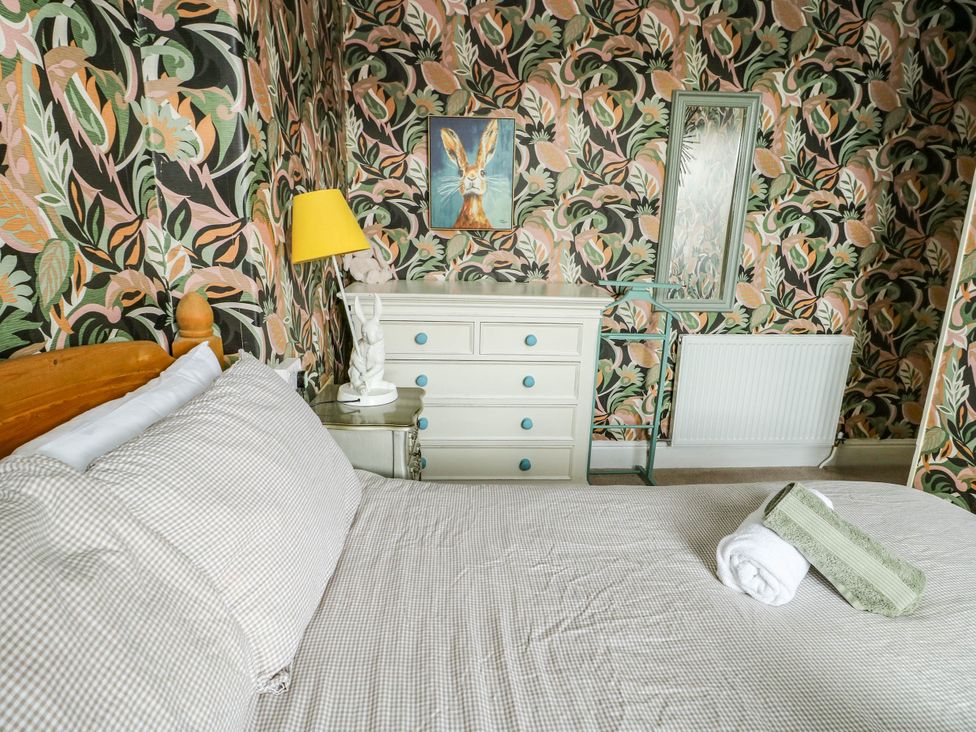 A bedroom with a bed and dresser at Flat 3 in Llandudno