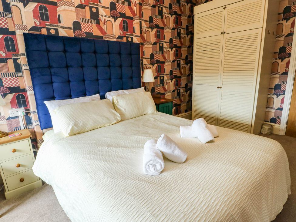 A bedroom with a bed and wardrobe at Flat 3 in Llandudno