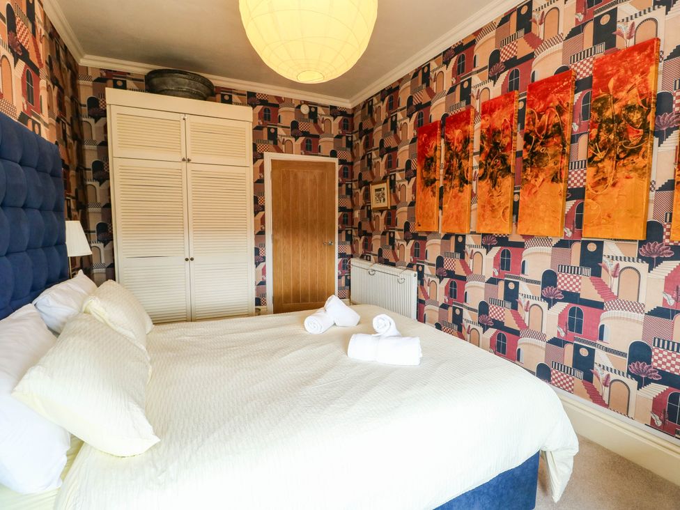 A bedroom with a bed and wardrobe at Flat 3 in Llandudno