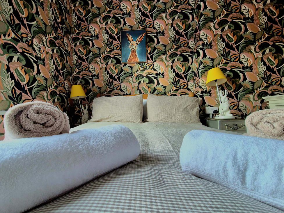 A bedroom with a bed and towels at Flat 3 in Llandudno