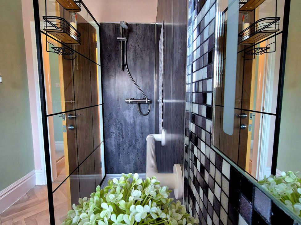 A bathroom with a shower and toilet at Flat 3 in Llandudno