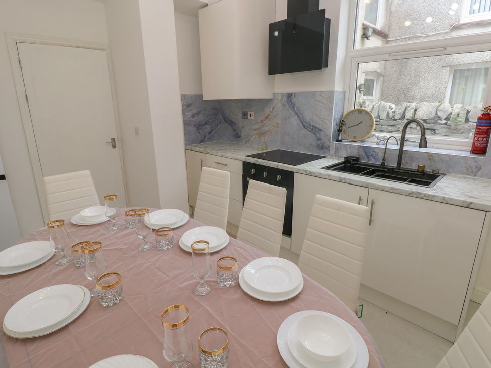 A dining room with a table set for dinner at 5 Gelli Terrace in Caerphilly