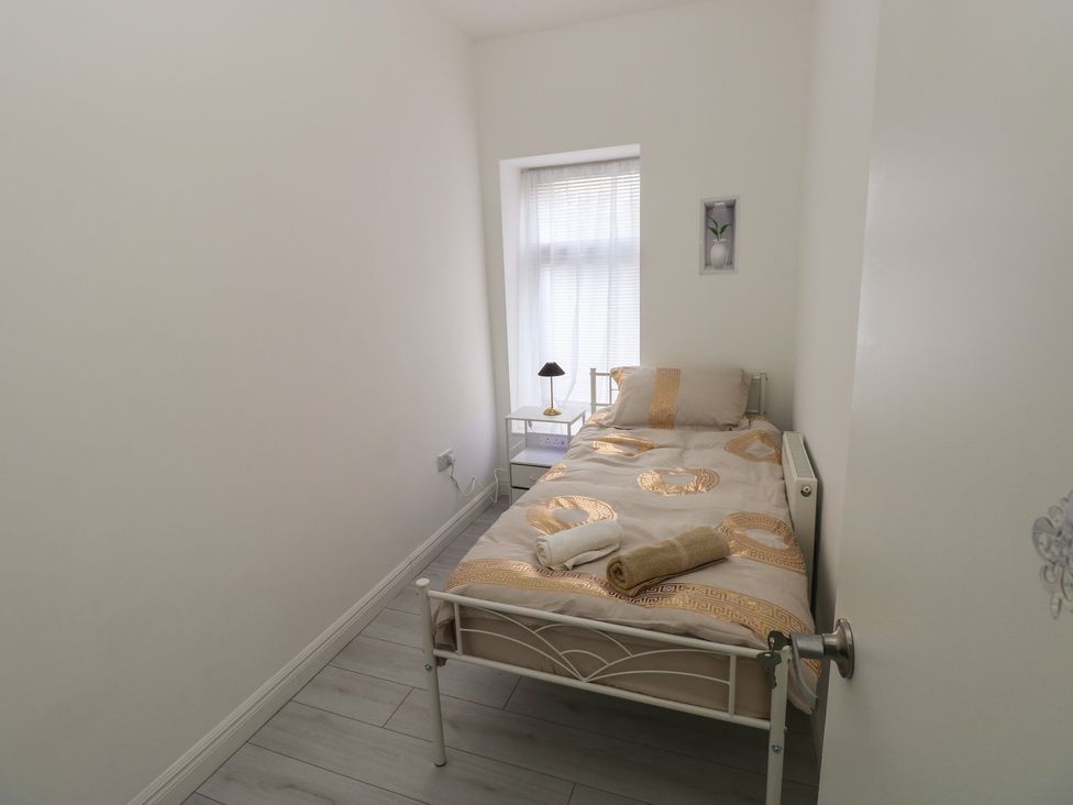 A bedroom with a bed and nightstand at 5 Gelli Terrace in Caerphilly