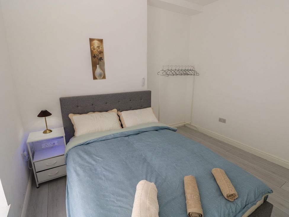 A bedroom with a bed and nightstand at 5 Gelli Terrace in Caerphilly