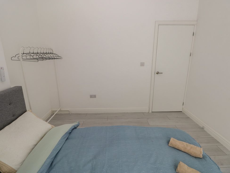A bedroom with a bed and hangers at 5 Gelli Terrace Caerphilly