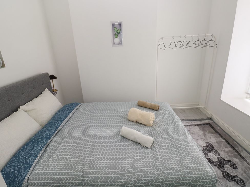 A bedroom with a bed and towels at 5 Gelli Terrace Caerphilly