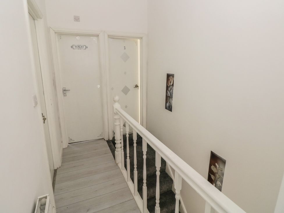 A hallway with a toilet door and room number door at 5 Gelli Terrace Caerphilly