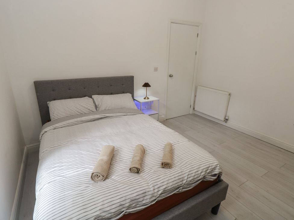 A bedroom with a bed and towels at 5 Gelli Terrace in Caerphilly