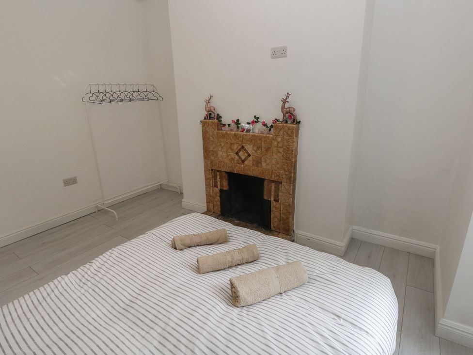 A bedroom with a bed and a fireplace at 5 Gelli Terrace in Caerphilly