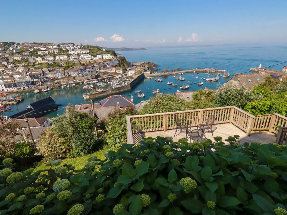 An outdoor area with a deck overlooking a harbor at Trewollock in Mevagissey
