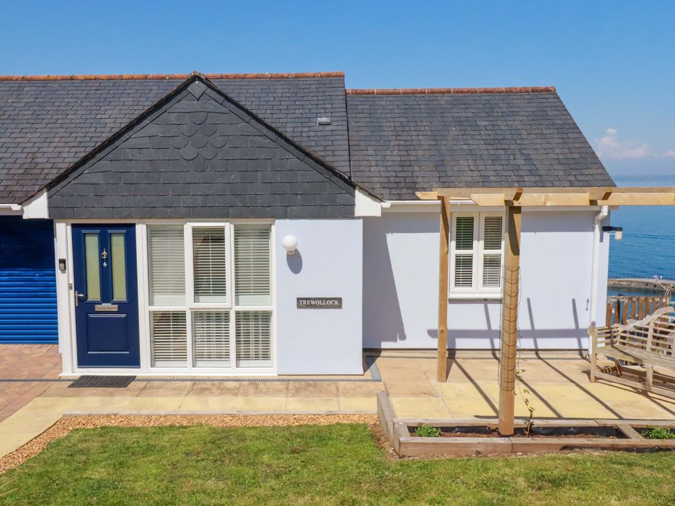 A house with a blue door and sign at Trewollock in Mevagissey