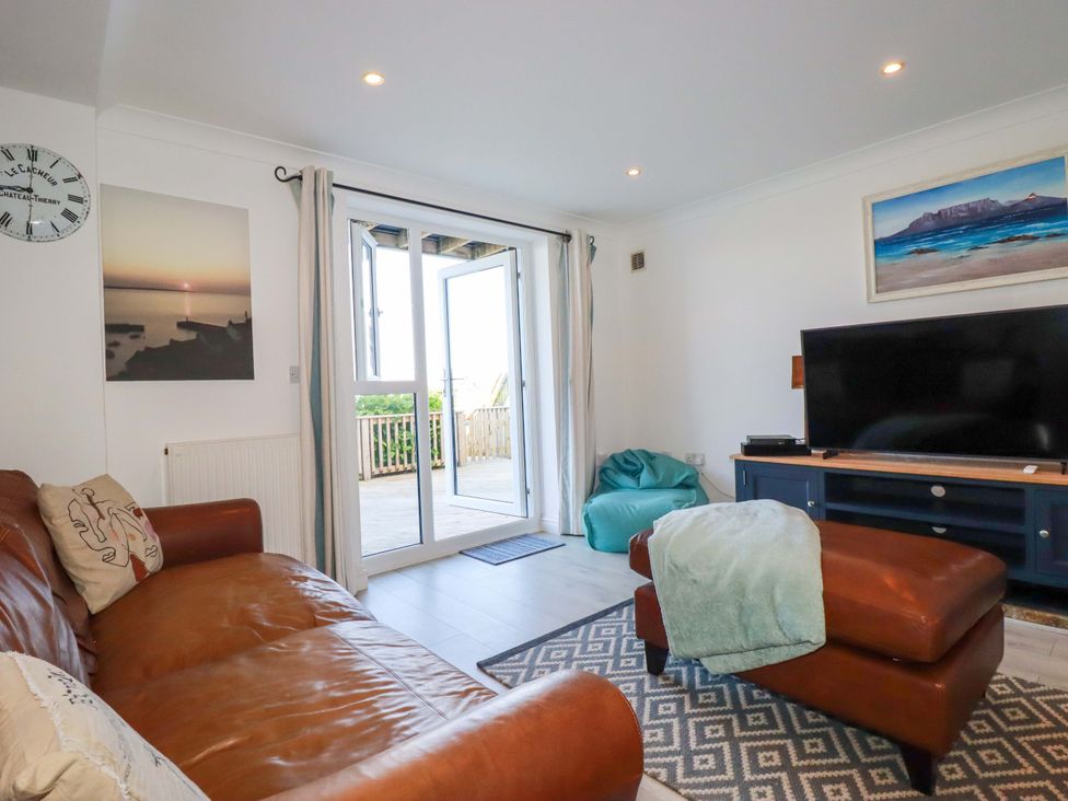 A living room with a sofa and television at Trewollock in Mevagissey