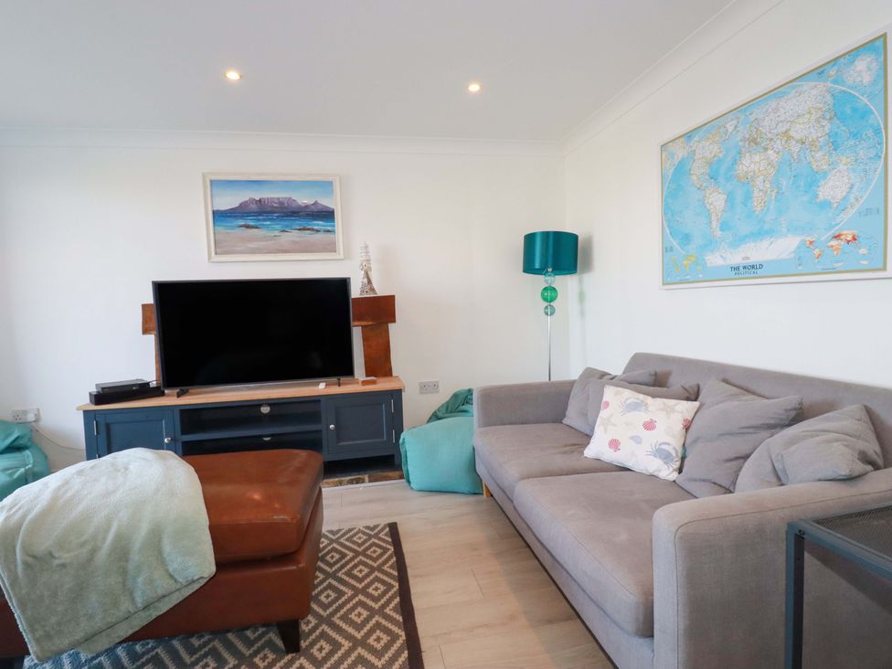 A living room with a television and a sofa at Trewollock in Mevagissey