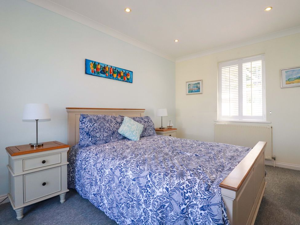 A bedroom with a bed and bedside tables at Trewollock in Mevagissey