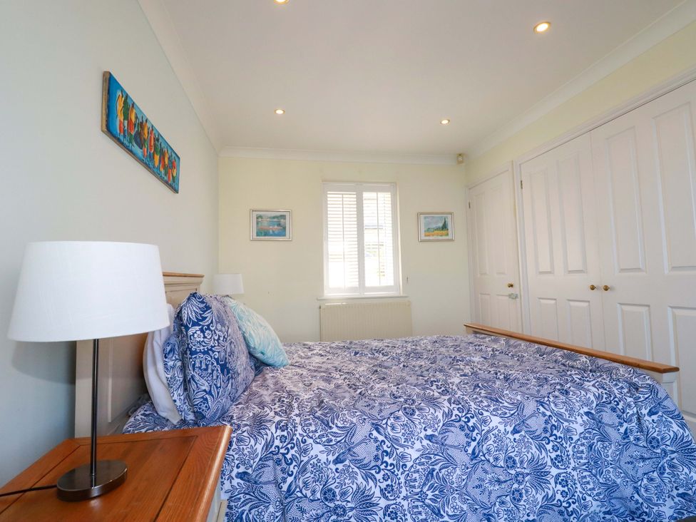 A bedroom with a bed and bedside lamp at Trewollock in Mevagissey
