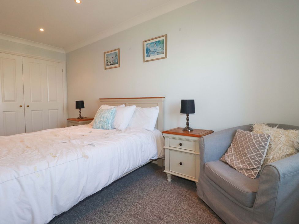 A bedroom with a bed and nightstand at Trewollock in Mevagissey